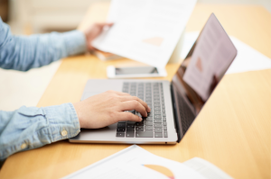 Person reviewing estate planning documents on a laptop at a desk