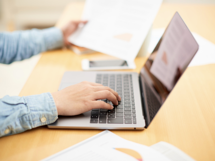 Person reviewing estate planning documents on a laptop at a desk