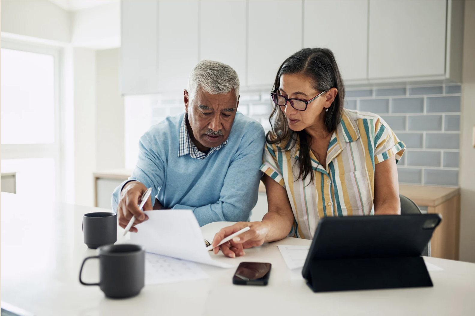 Couple reviewing estate planning documents together at a kitchen table