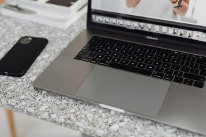 Laptop computer on a desk next to a smartphone