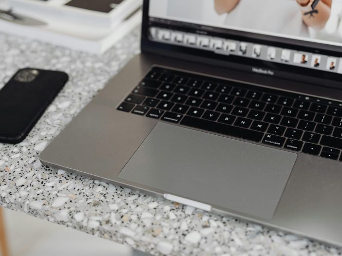 Laptop computer on a desk next to a smartphone