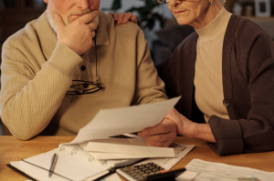 An older couple sitting at a table reviewing paperwork together