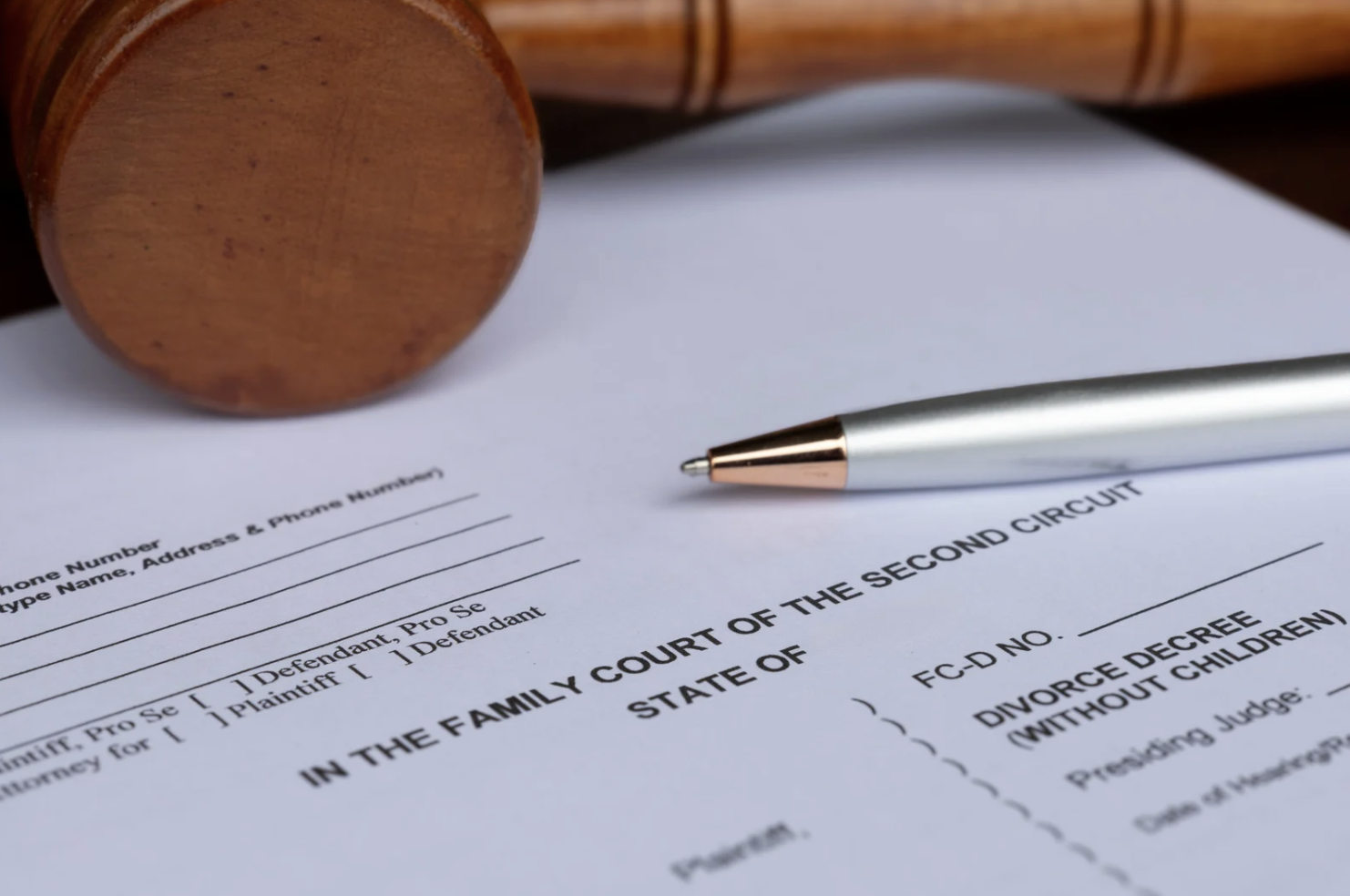 final decree of divorce document with wooden gavel and pen on desk