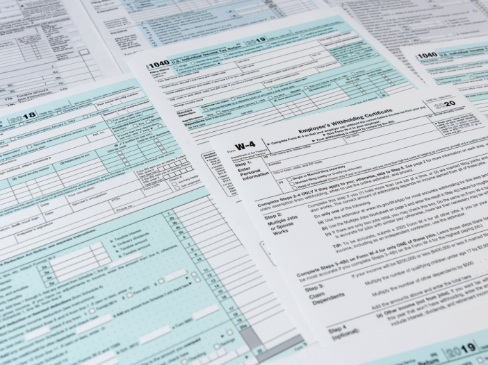 IRS Form 1040 and W-4 tax documents spread across a desk during tax preparation