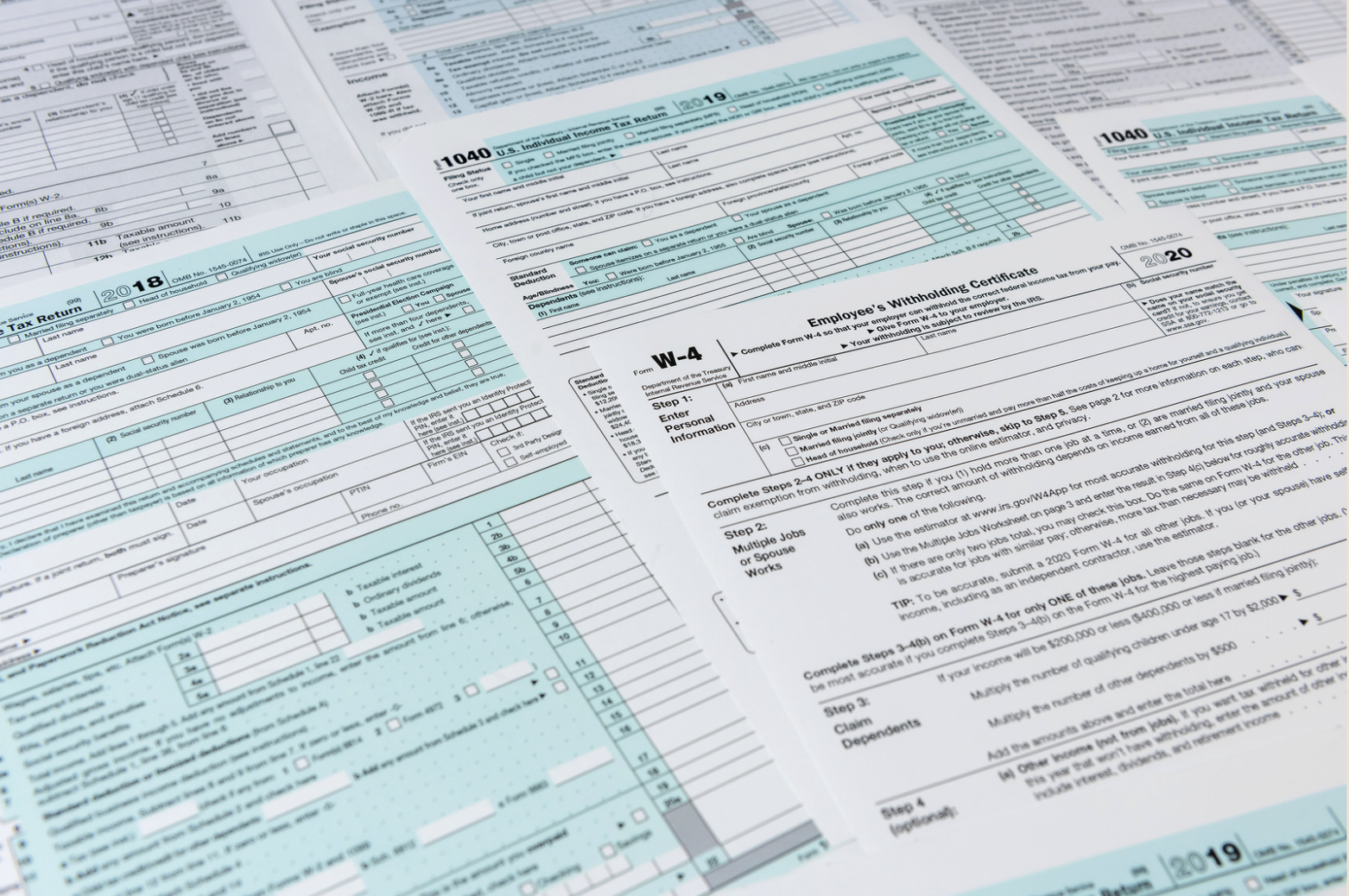 IRS Form 1040 and W-4 tax documents spread across a desk during tax preparation