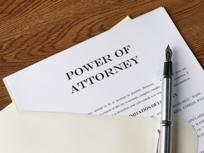 A power of attorney document and fountain pen on a wooden desk