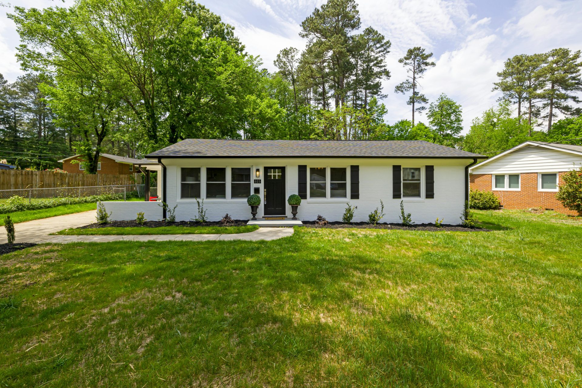 Single-story brick home with a green lawn on a clear day in Alabama