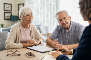 Two adults seated at a table reviewing documents together with an advisor.