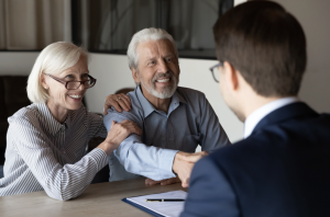 Financial advisor and clients reviewing estate planning documents at a desk