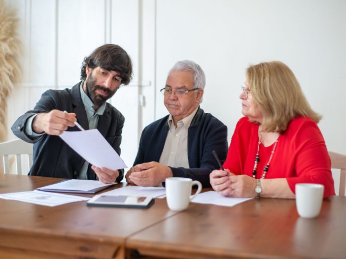 Financial advisor and client reviewing documents together at a desk