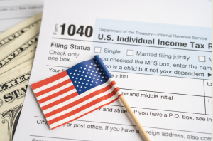 Tax forms and a small American flag on top.