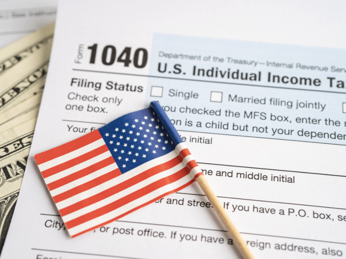 Tax forms and a small American flag on top.