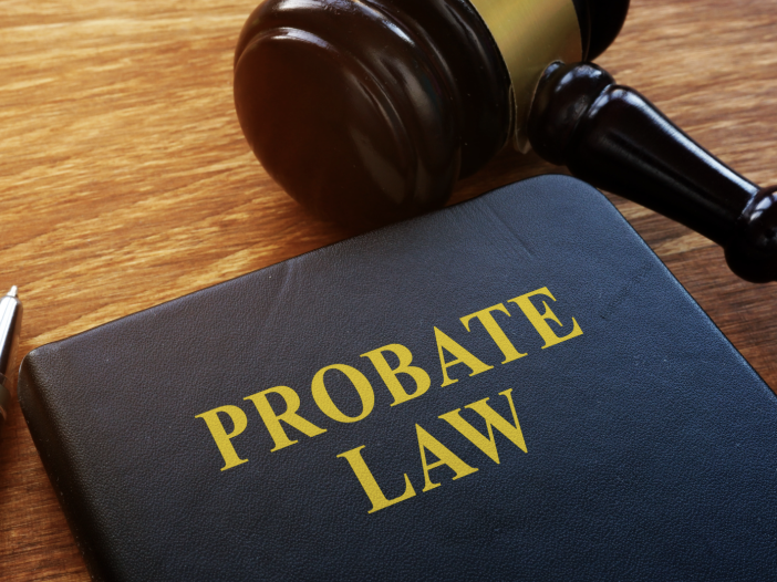 A probate law book next to a judge's gavel and pen