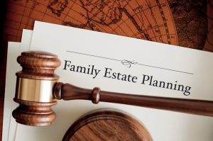 Wooden gavel resting on cream papers titled Family Estate Planning, with an antique map in the background