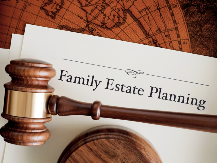 Wooden gavel resting on cream papers titled Family Estate Planning, with an antique map in the background